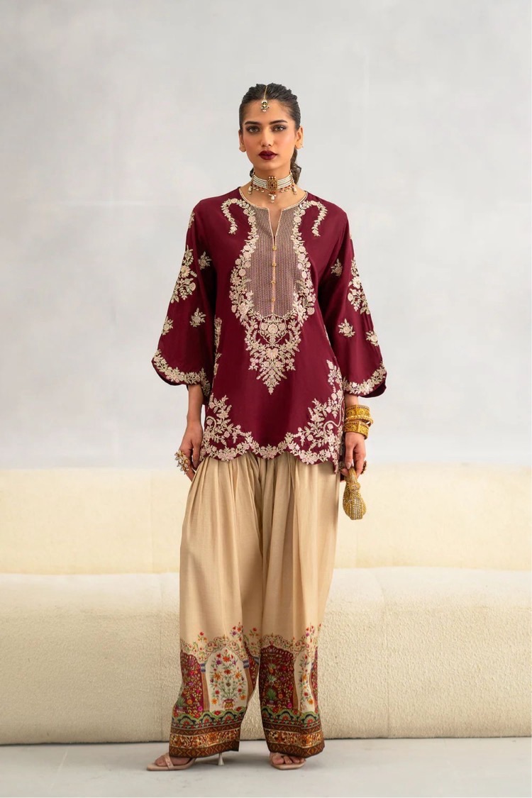 Stunning red heavy embroidered pure velvet two-piece Pakistani festive suit paired with a digital printed silk trouser.