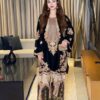 Pakistani woman wearing a black heavy embroidered pure velvet 2-piece suit with a digital printed silk trouser.