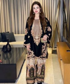 Pakistani woman wearing a black heavy embroidered pure velvet 2-piece suit with a digital printed silk trouser.